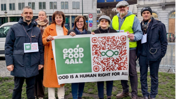 Eight people stand together outside the European Parliament holding a “Good Food 4 All” banner with the message “Food is a human right for all” and a large QR code.