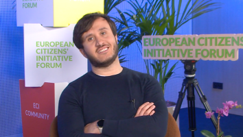 Salvatore Ricci, organiser of the ECI Stop Funding Russia’s War sits in from of promotional material of the ECI Forum during the ECI Day 2026 while being interviewed.