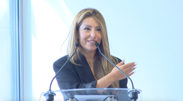 A medium shot of Greek journalist and TV presenter Anastasia Giamali delivering a speech at a podium during a press conference in Brussels.