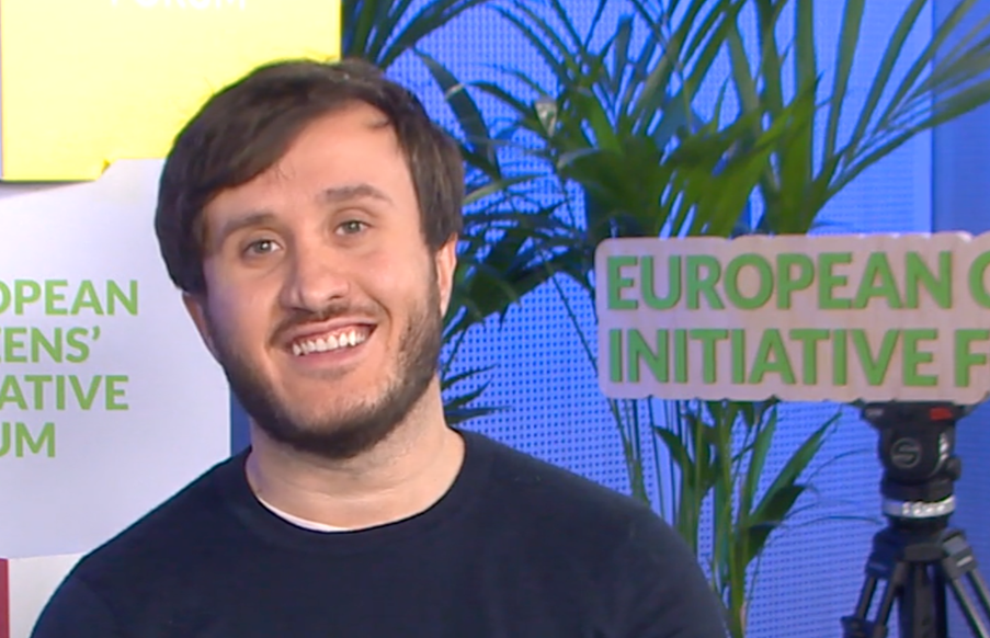 Salvatore Ricci, organiser of the ECI Stop Funding Russia’s War sits in from of promotional material of the ECI Forum during the ECI Day 2026 while being interviewed.